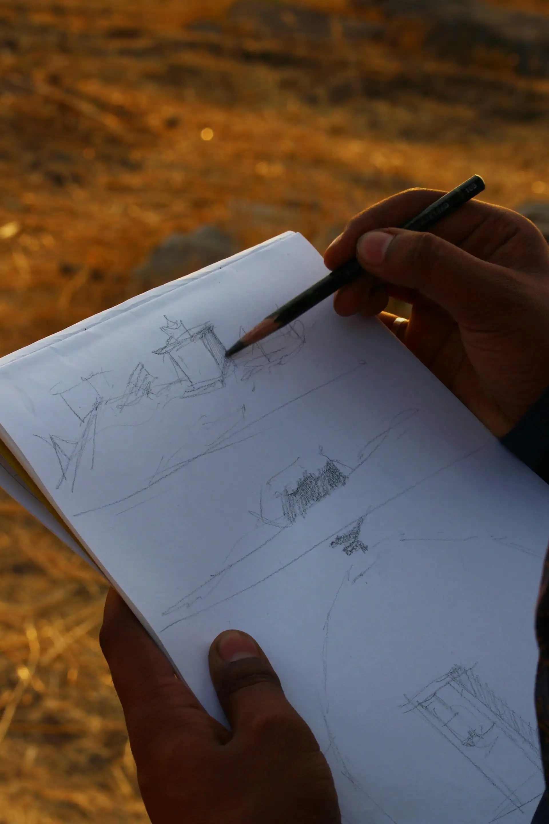 Designer sketching a garden plan at a table outdoors